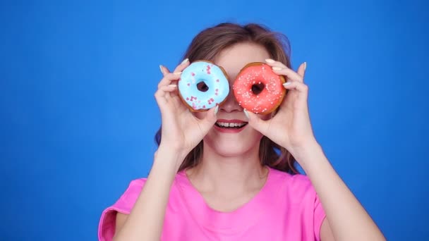 Donna di bellezza prendendo ciambelle colorate. Divertente ragazza gioiosa con dolci — Video Stock