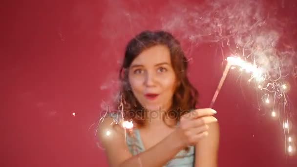 Young attractive celebrating woman holding sparkles and dancing — Stock Video