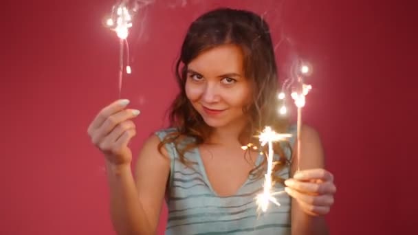 Young attractive celebrating woman holding sparkles and dancing — Stock Video