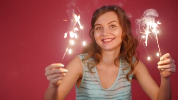 Mulher sorridente bonita dançando com um sparkler — Vídeo de Stock