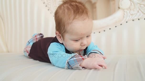 Niedliches Baby liegt auf dem Sofa — Stockvideo