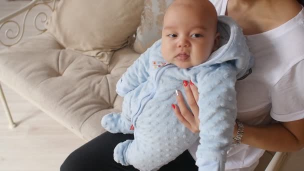 Moeder bedrijf pasgeboren baby in haar armen thuis — Stockvideo