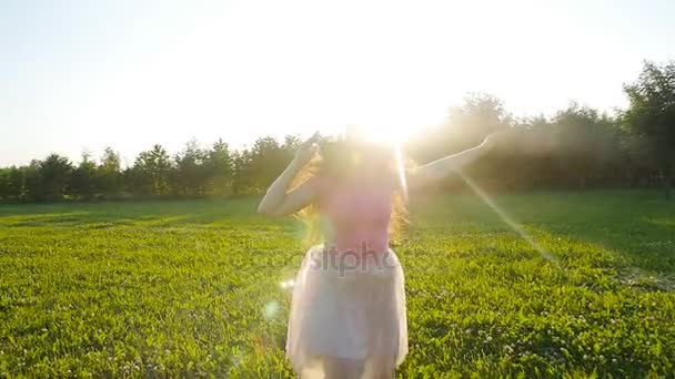 Šťastná mladá žena běží na louku za slunečného podzimního dne — Stock video