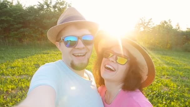 Feliz pareja viajera haciendo selfie colores soleados de verano al atardecer — Vídeo de stock