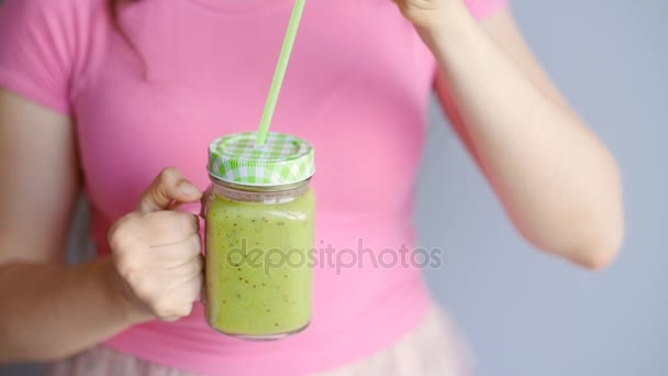 Jovem mulher bonita desfrutando de um smoothie vegetal de fruta crua saudável — Vídeo de Stock