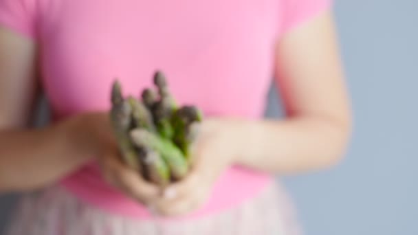 Happy woman holding showing asparagus in closeup — Stock Video