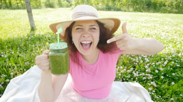 Junge Frau mit grünen Gemüse-Smoothies im Park — Stockvideo