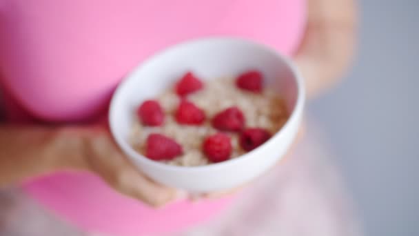 Manos de mujer sosteniendo una taza con avena orgánica y bayas — Vídeos de Stock