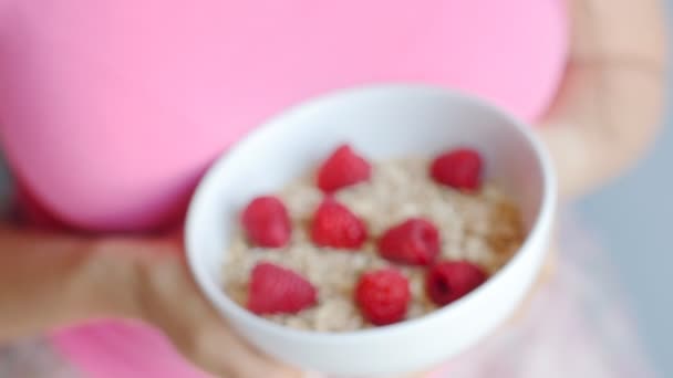 Womans hands holding a cup with organic oats and berries — Stock Video