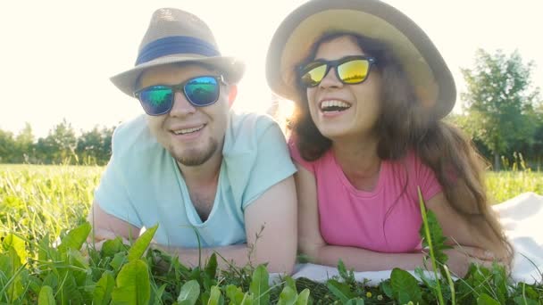 Young couple having fun on the grass in a park — Stock Video