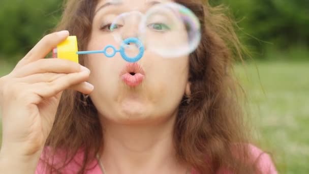 Женщина, пускающая мыльные пузыри на закате — стоковое видео