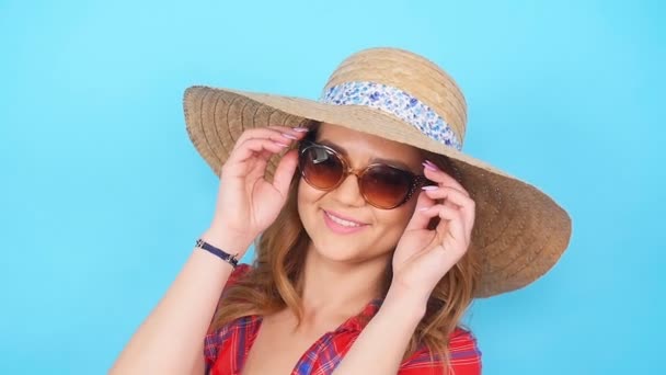 Jonge vrouw in zonnebril en hoed glimlachen — Stockvideo