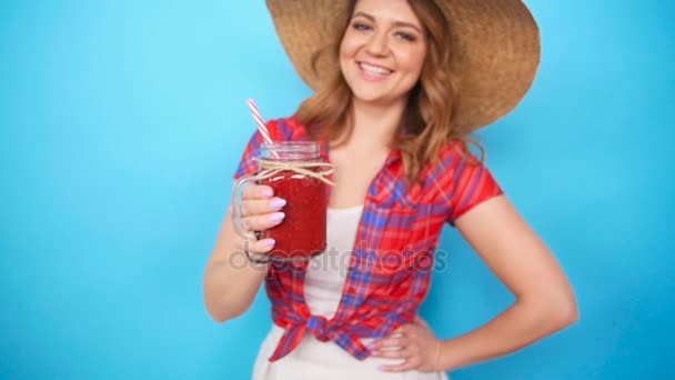 Hermosa joven sosteniendo un batido rojo — Vídeos de Stock