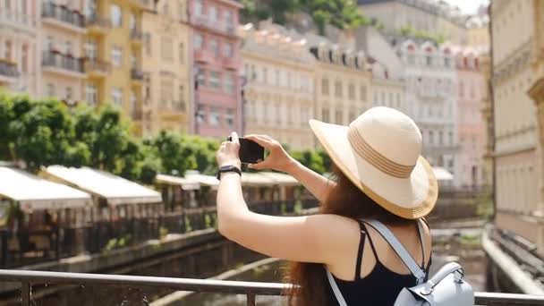 Chica viajera están utilizando un teléfono inteligente para capturar la imagen de la ciudad vieja — Vídeos de Stock