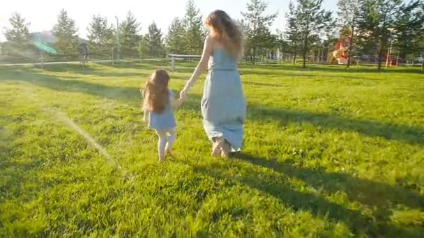 Joven madre corriendo con su hija al aire libre en cámara lenta — Vídeos de Stock