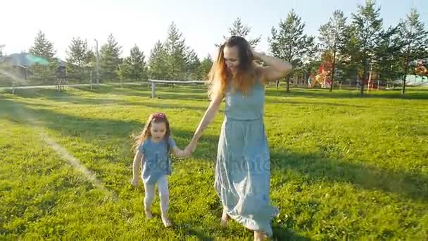 Genç anne ile kızı yavaş çekimde açık havada çalışan — Stok video
