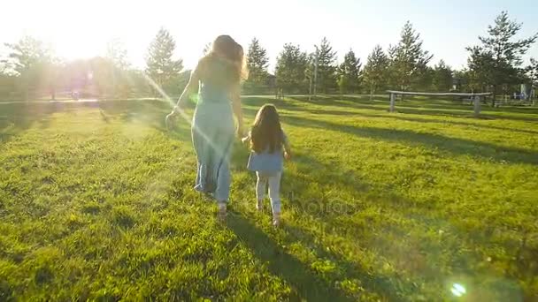 Jeune mère courant avec sa fille à l'extérieur au ralenti — Video