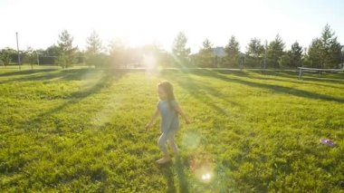 Küçük mutlu kız yeşil çayır ağır çekimde çalıştıran