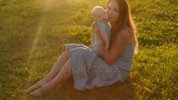 Силует матері з дитиною на заході сонця — стокове відео