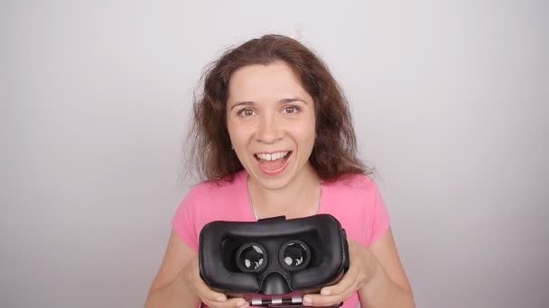 Junge Frau gibt Virtual-Reality-Brille auf weißem Hintergrund — Stockvideo