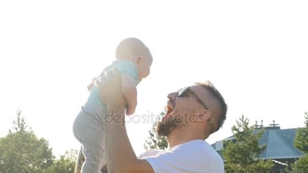 Счастливый отец держит сына на закате — стоковое видео