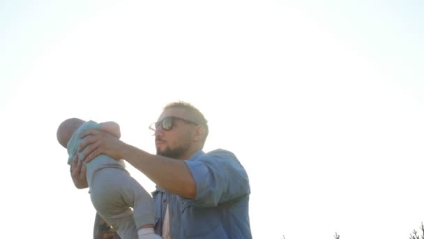 Feliz padre sosteniendo a su hijo al atardecer — Vídeos de Stock