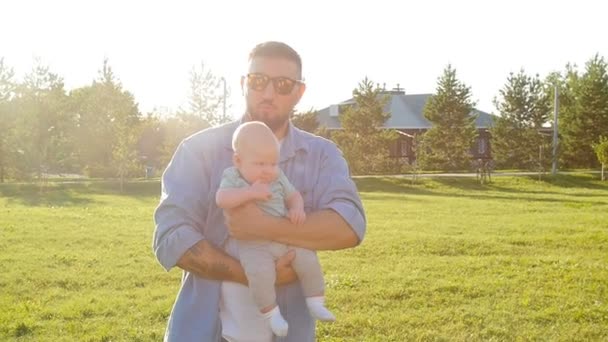 Feliz padre sosteniendo a su hijo al atardecer — Vídeos de Stock