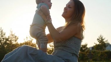 Onun kollarında küçük bir oğlu tutan genç bir anne