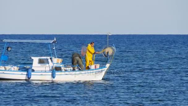 Protaras, Cypern - februari 3, 2016: Fisherman simmar på hans fiskebåt i havet — Stockvideo