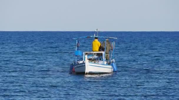 Protaras, Cypern - februari 3, 2016: Fisherman simmar på hans fiskebåt i havet — Stockvideo