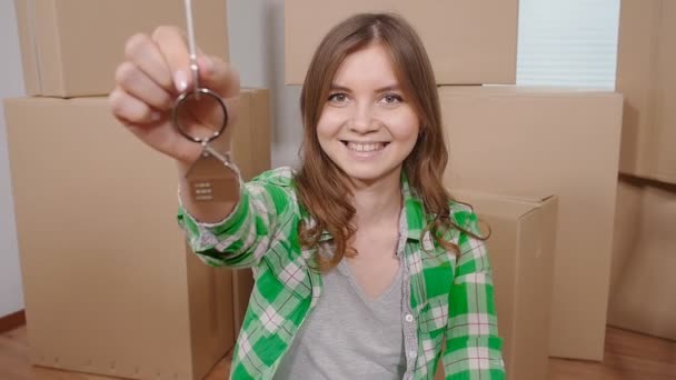 Glad ung kvinna med en nyckel från en ny lägenhet — Stockvideo