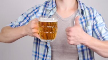 Genç adam bir bardak bira ile
