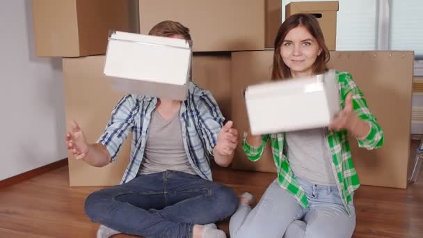 Joven sonriente pareja moviéndose en nuevo hogar — Vídeo de stock