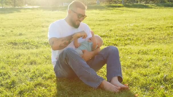 Père et petit fils sur l'herbe dans le parc — Video