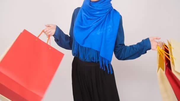 幸せな若いイスラム教徒の女性が買い物袋を運ぶ. — ストック動画