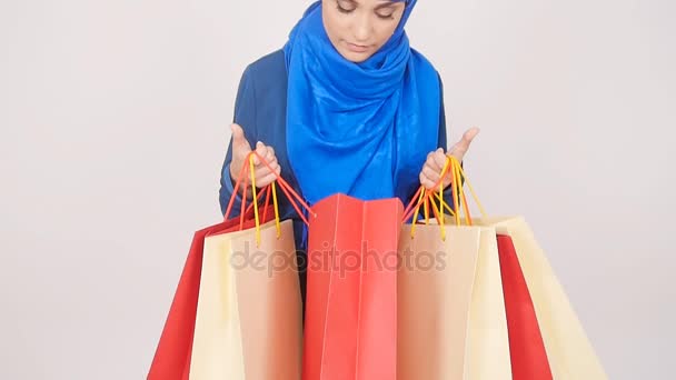 Jovem muçulmana feliz está carregando saco de compras . — Vídeo de Stock