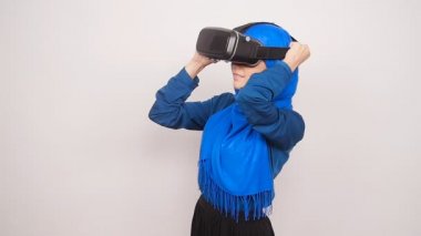 Sanal gerçeklik gözlüklü genç bir Müslüman kadın