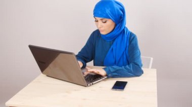 Dizüstü bilgisayar kullanan genç Arap kadın