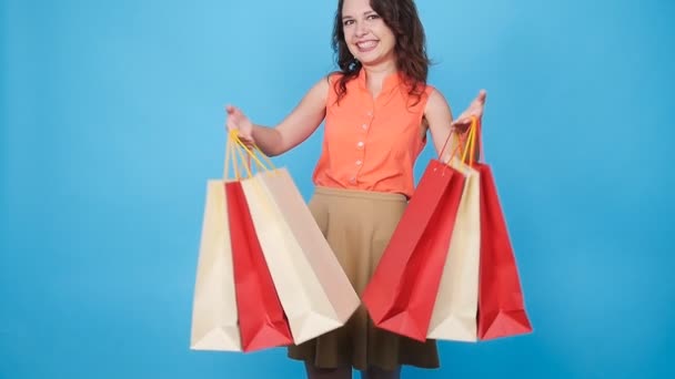 Feliz joven mujer llevando bolsas de compras — Vídeo de stock