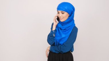 Genç Müslüman kadın cep telefonundan söz