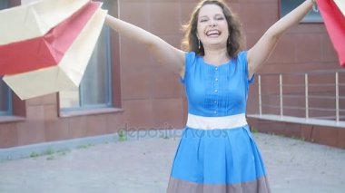 Mutlu genç kadın elinde alışveriş torbaları ile çalışan