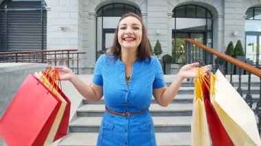 alışveriş torbaları ile gülümseyen genç kadın