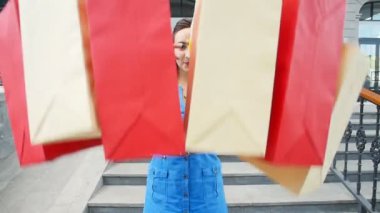 alışveriş torbaları ile gülümseyen genç kadın