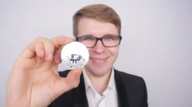 Bir madeni para bitcoin olan genç bir adam