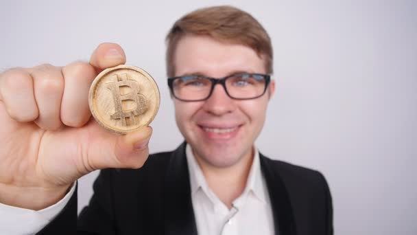 Een jonge man met een munt bitcoin — Stockvideo