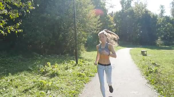 Досить молода спортивна жінка біжить в парку — стокове відео