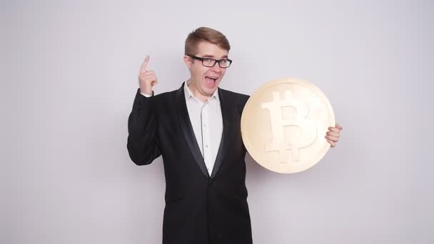 Ein Mann hält eine große Münze Bitcoin — Stockvideo