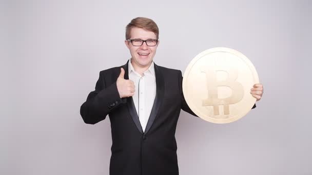 Ένας άνδρας που κρατά ένα μεγάλο νόμισμα bitcoin — Αρχείο Βίντεο