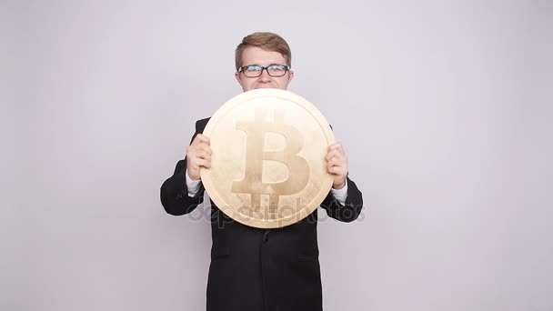 Seorang pria memegang koin bitcoin besar — Stok Video
