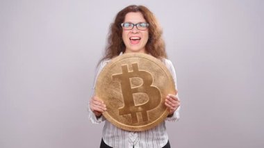 Mutlu kadın büyük Bitcoin para gösteriliyor. Sanal para kavramı. Cryptocurrency